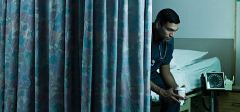 Doctor sitting behind curtain